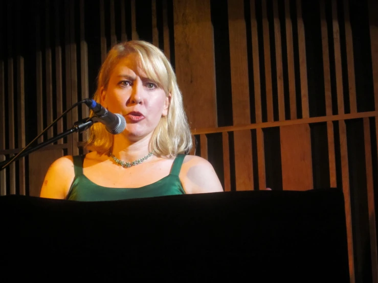 a woman holding up a microphone and giving a speech