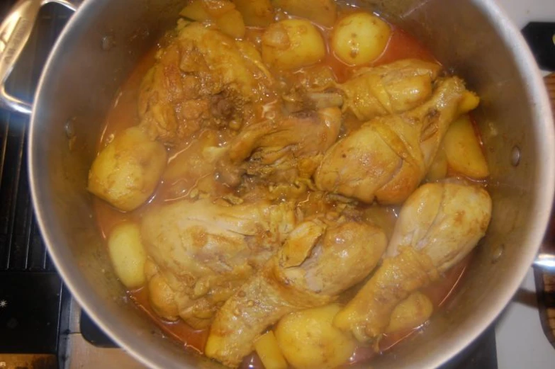 a pot of meat and potatoes boiling on the stove