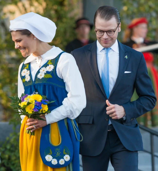 two people dressed in traditional german clothing walk