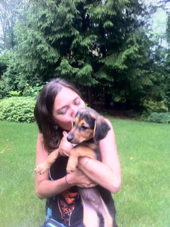 a woman in the park holding her small dog