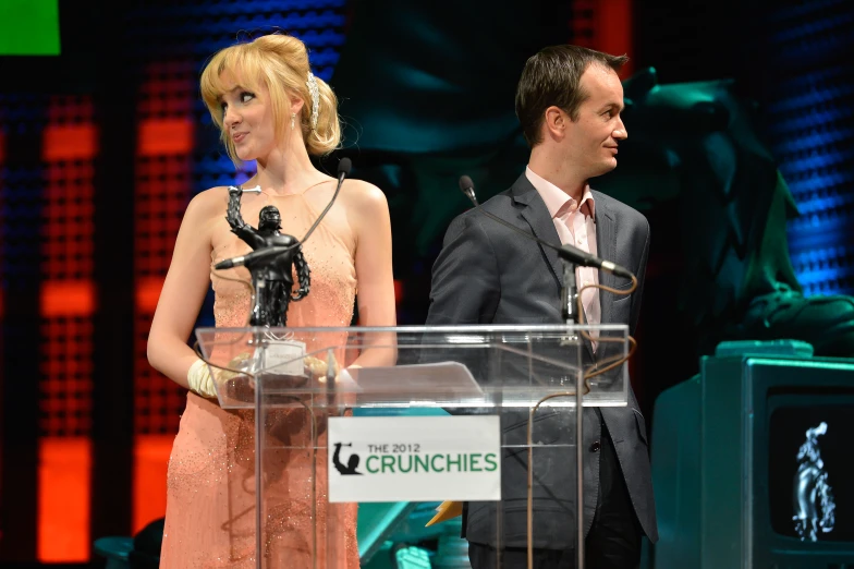 the couple stands behind the podium at the awards