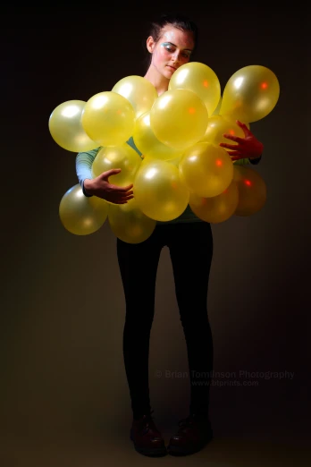 a person wearing a suit and holding onto a bunch of balloons