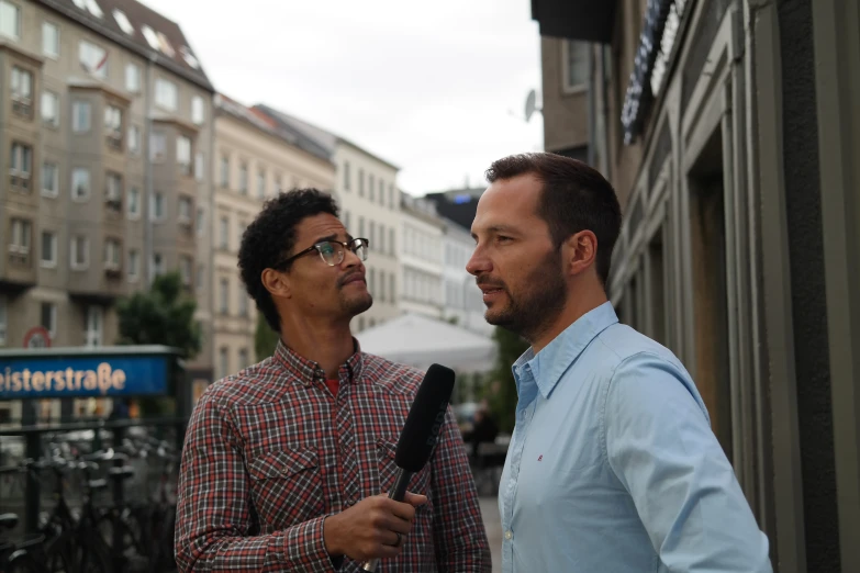 two men on a city street are talking