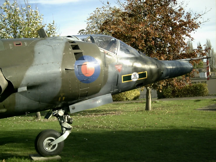 an old propeller jet parked on the grass