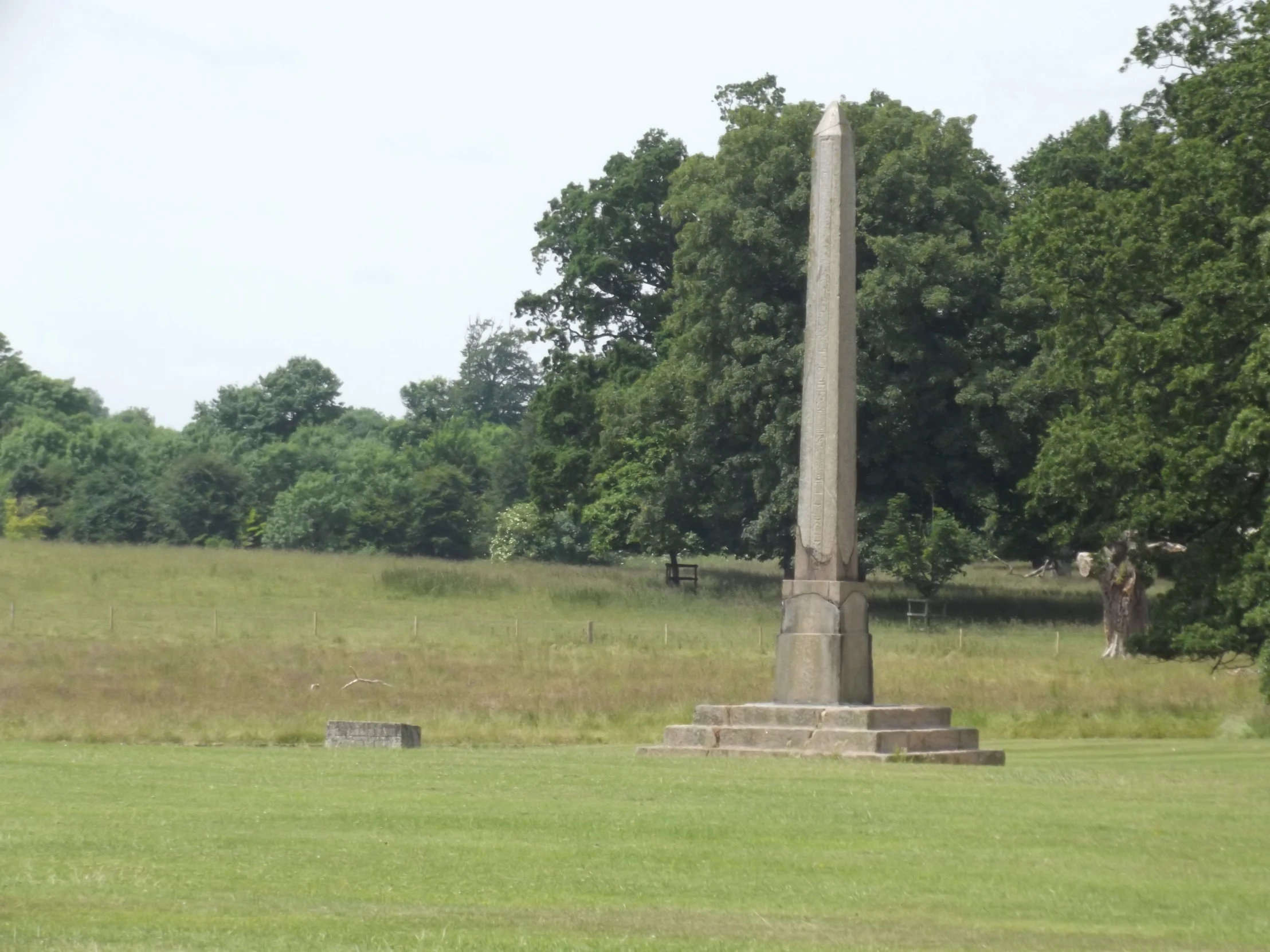 three tall pillars sitting in the middle of a grass covered field