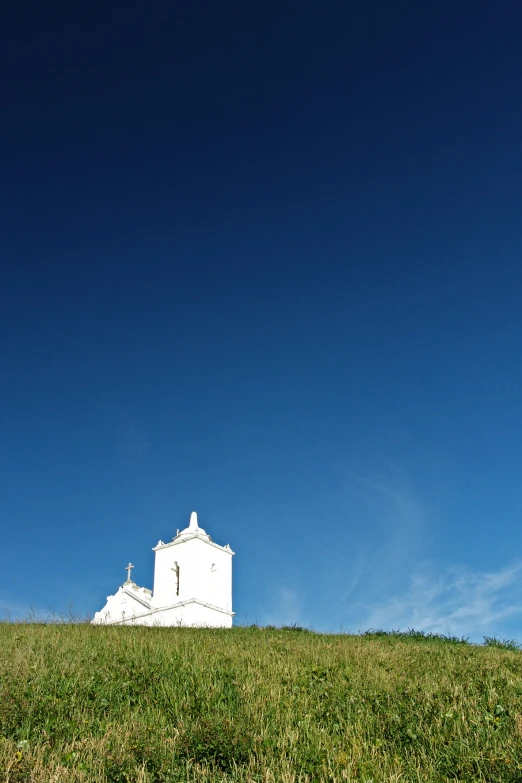 the building is on top of a grassy hill