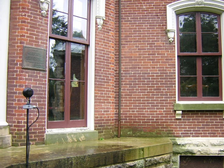 brick building with an outside concrete stair leading to the outside