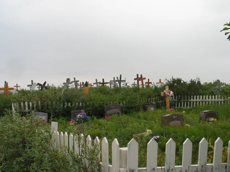 several crosses are on the side of a cemetery