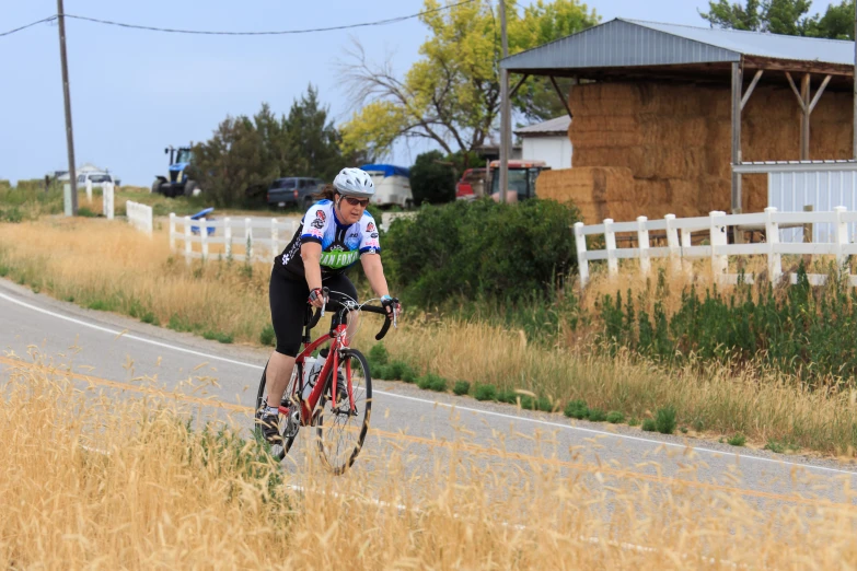 a person riding a bike on a rural street