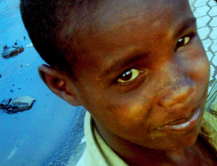 a young child staring at the camera on a sunny day