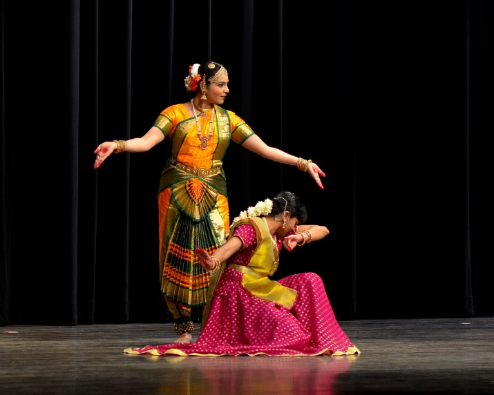 two women in costumes performing a dance