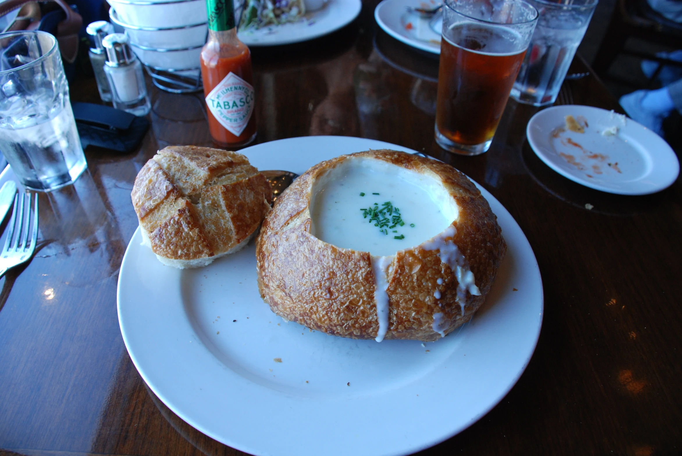 two soups on a plate with a few glasses and saucers