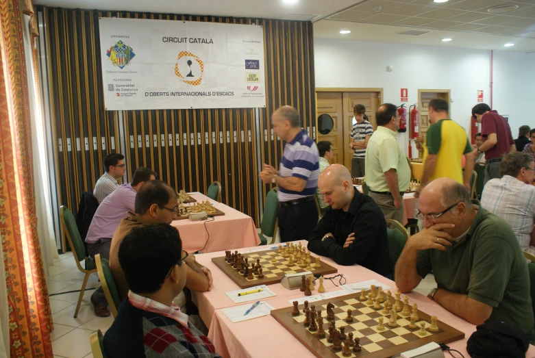 a group of people watching a man play a game of chess