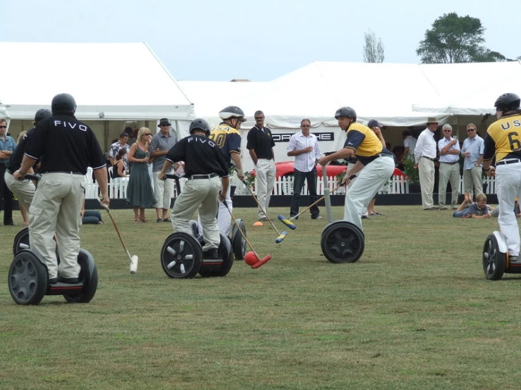 a group of men standing on top of segways in a field