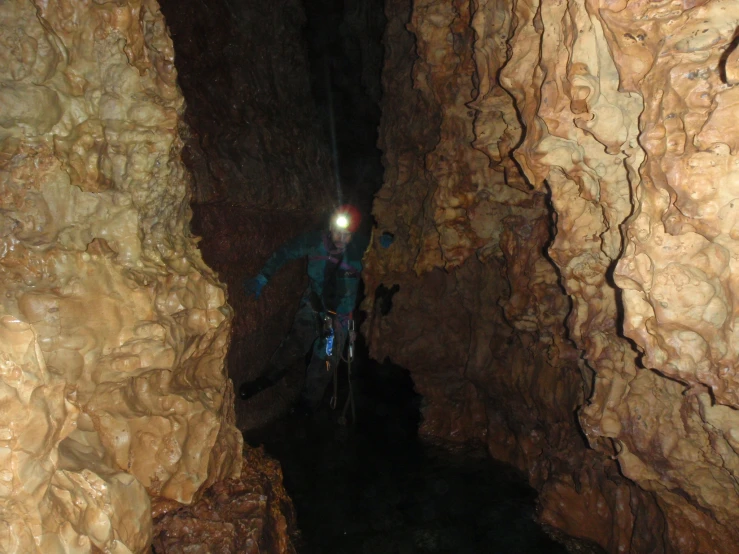 man on bicycle inside of a cave with rocks and water