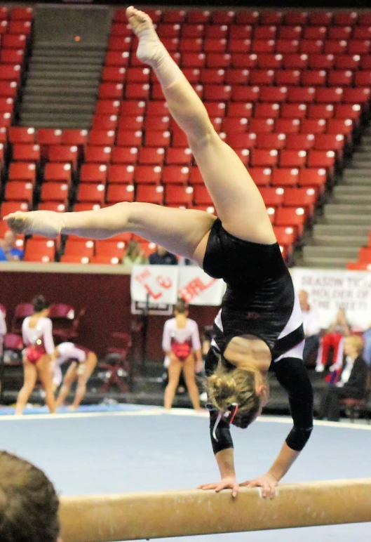 a girl that is standing on a beam