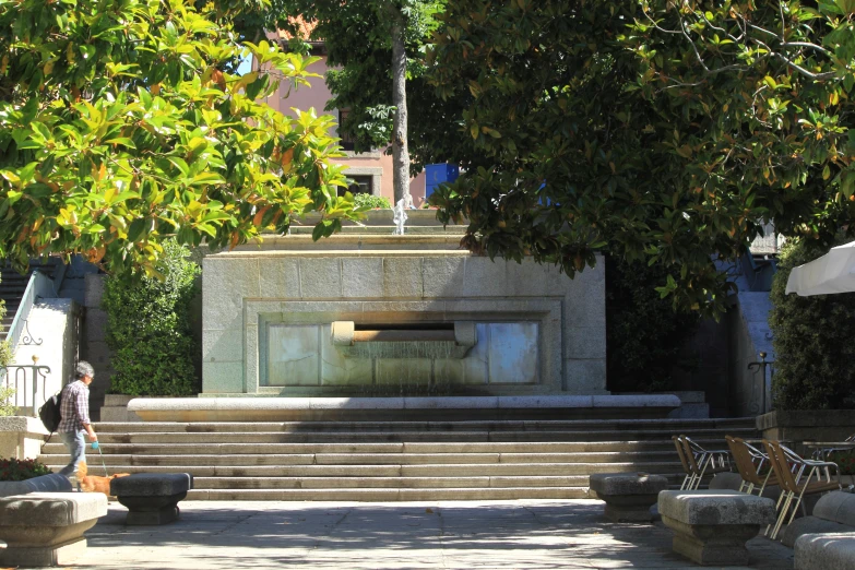 an outdoor stone fountain with plants near the sides
