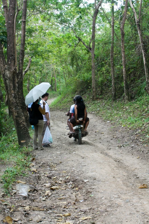 two people stand with their skateboards on the road