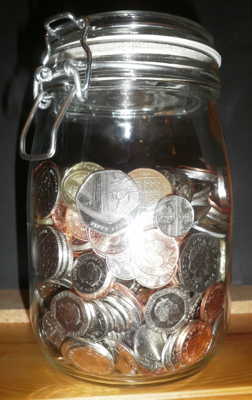 a glass jar that has some coins in it