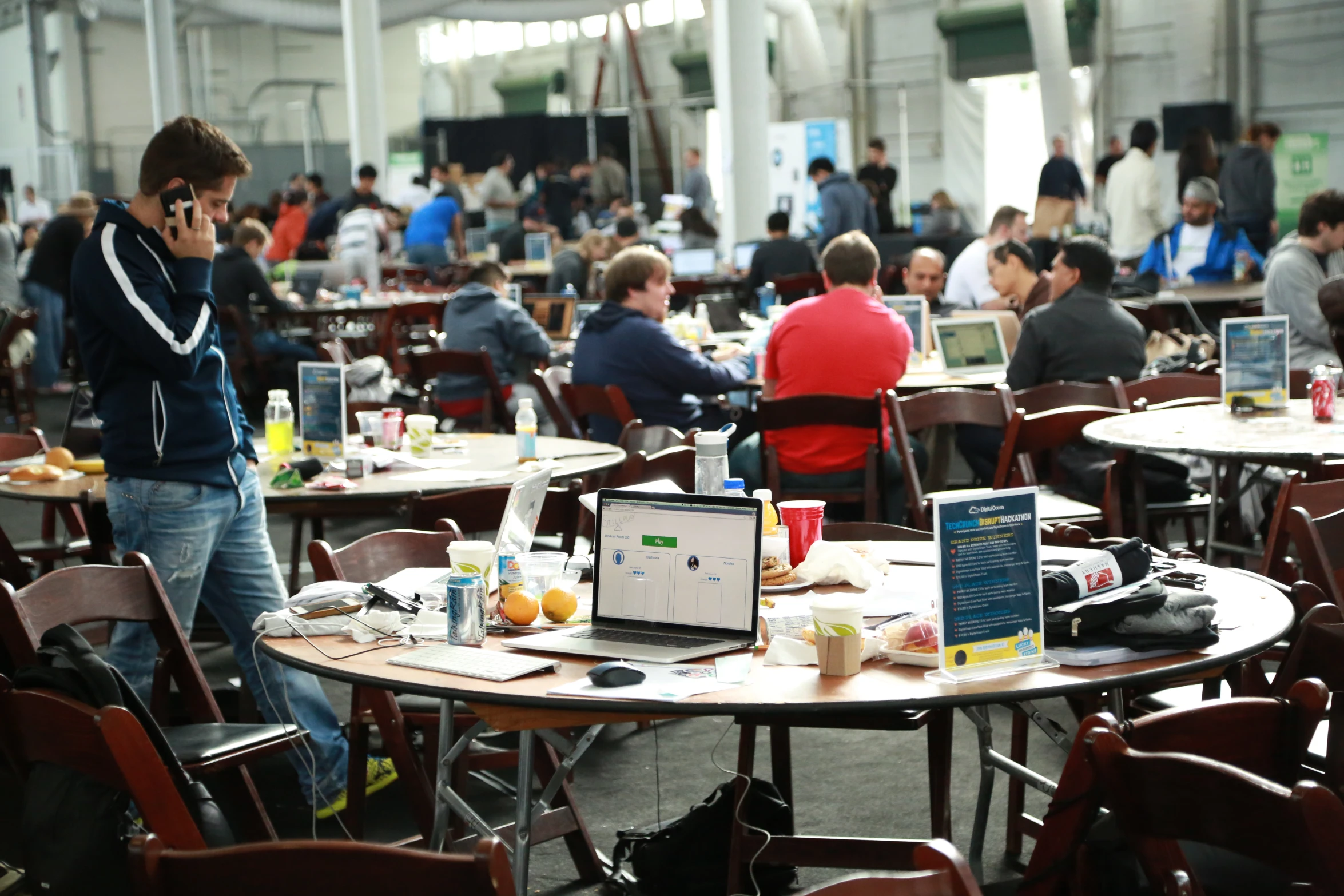 the people in the cafe have their laptops and other items on tables