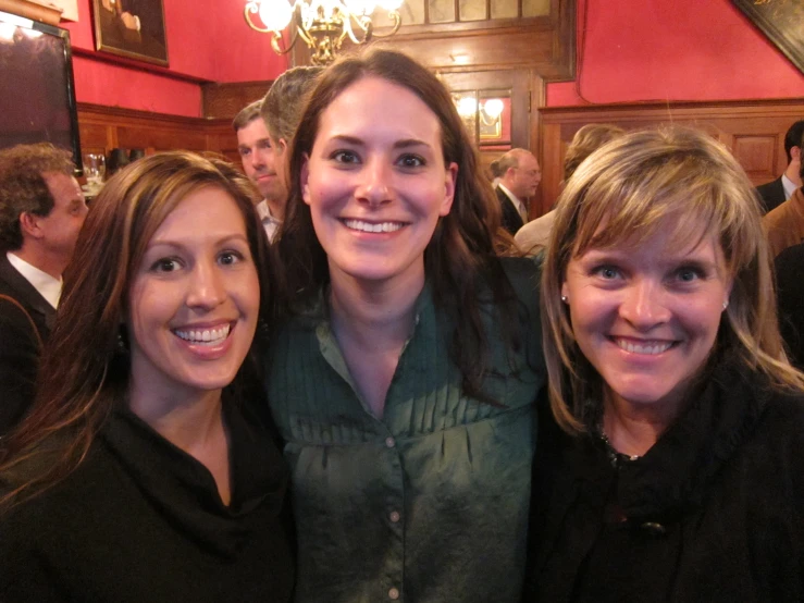 three women posing for the camera in a restaurant