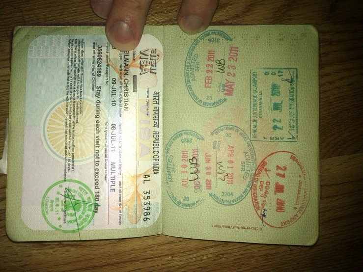 a hand is holding two different colored passenger pass papers