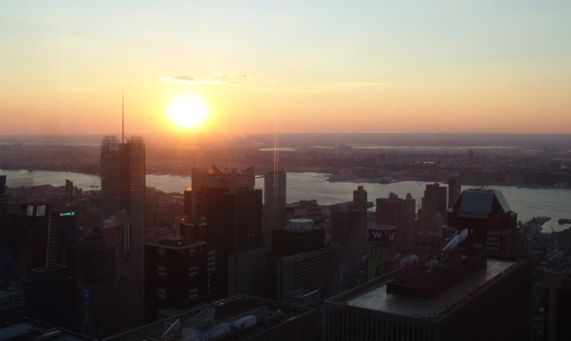 the sun rising over a large city as it shines