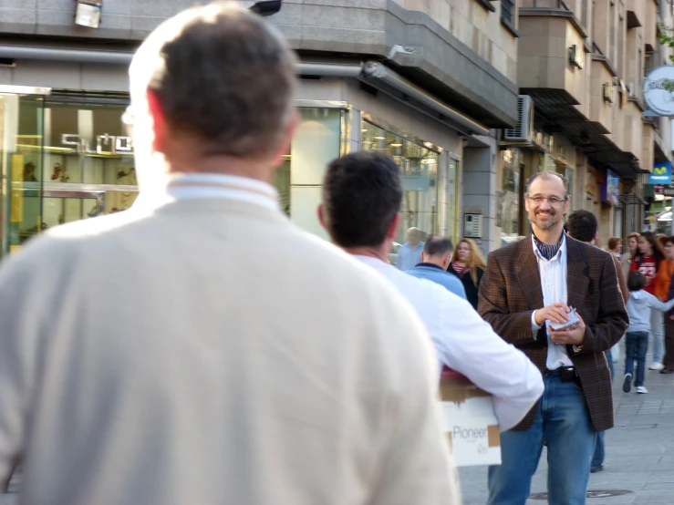 a man walking down the street between many other people