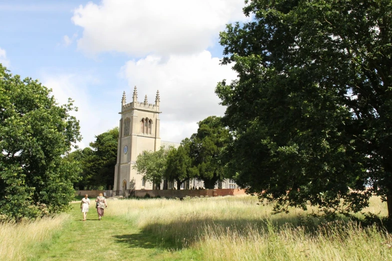 a large building near a grassy field and trees