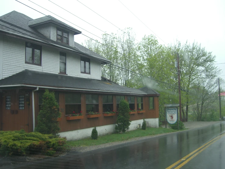 some houses sitting on a road while rain has come