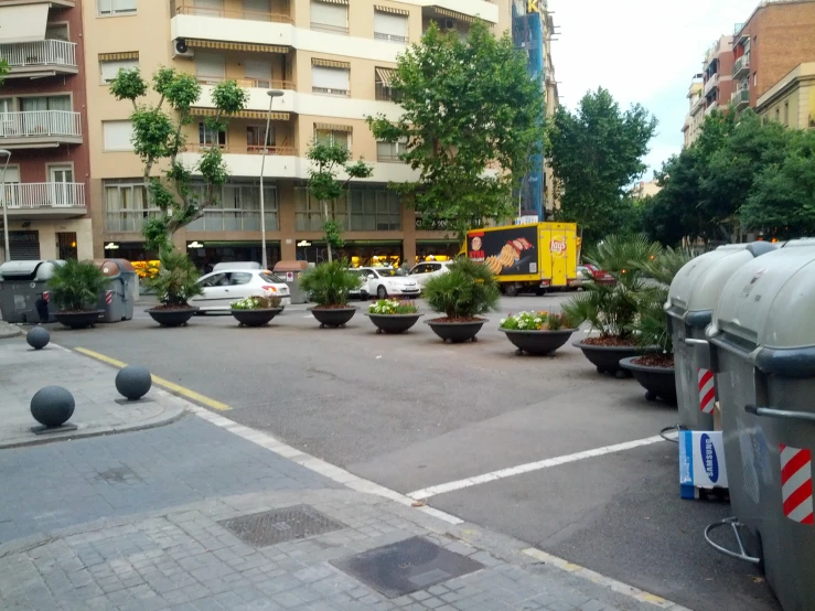 several trash bins sit in the middle of a busy street