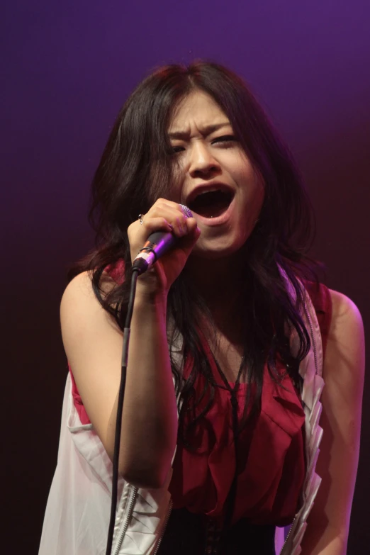 a woman is screaming while singing into a microphone