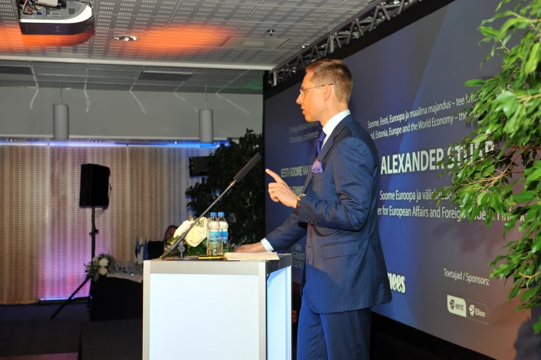 a man in a suit speaking at a podium