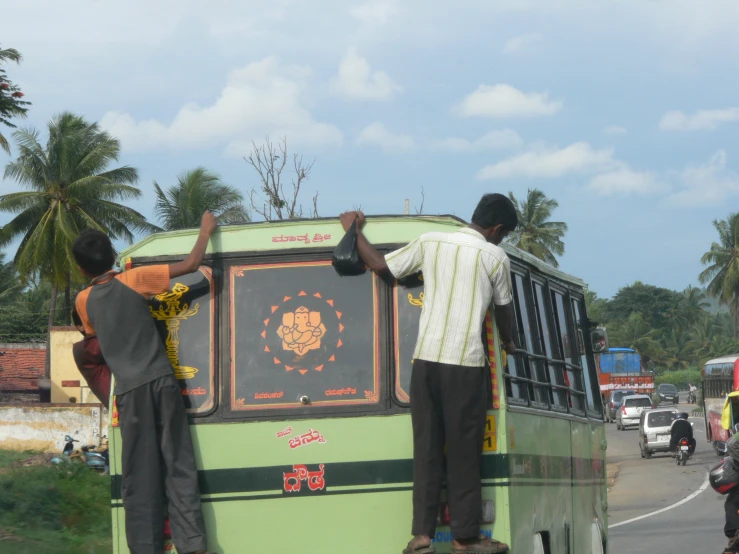 men in front of a bus making repairs