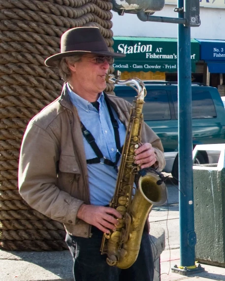 a man is holding a saxophone on the sidewalk