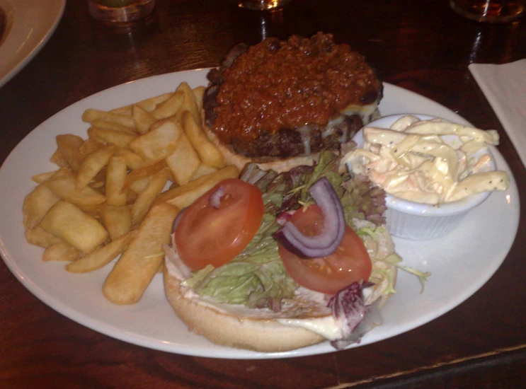 an onion sandwich and fries on a white plate