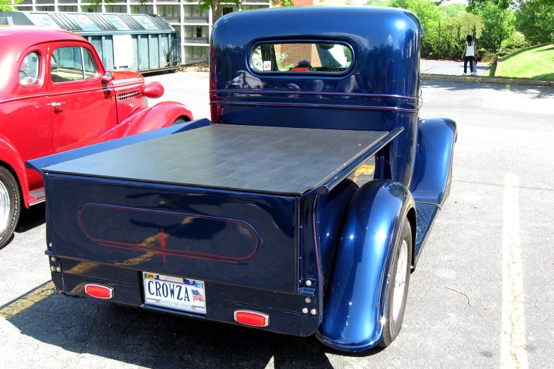 an antique blue pickup truck sitting in a parking lot