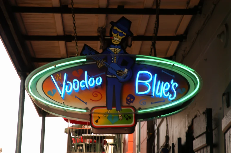 a neon sign on a store front that says voodoo blues