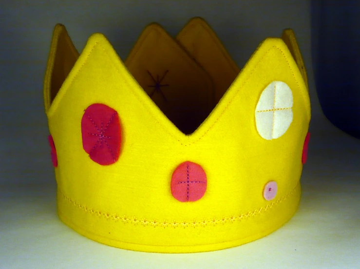 a paper crown with two little red dots on the middle of it