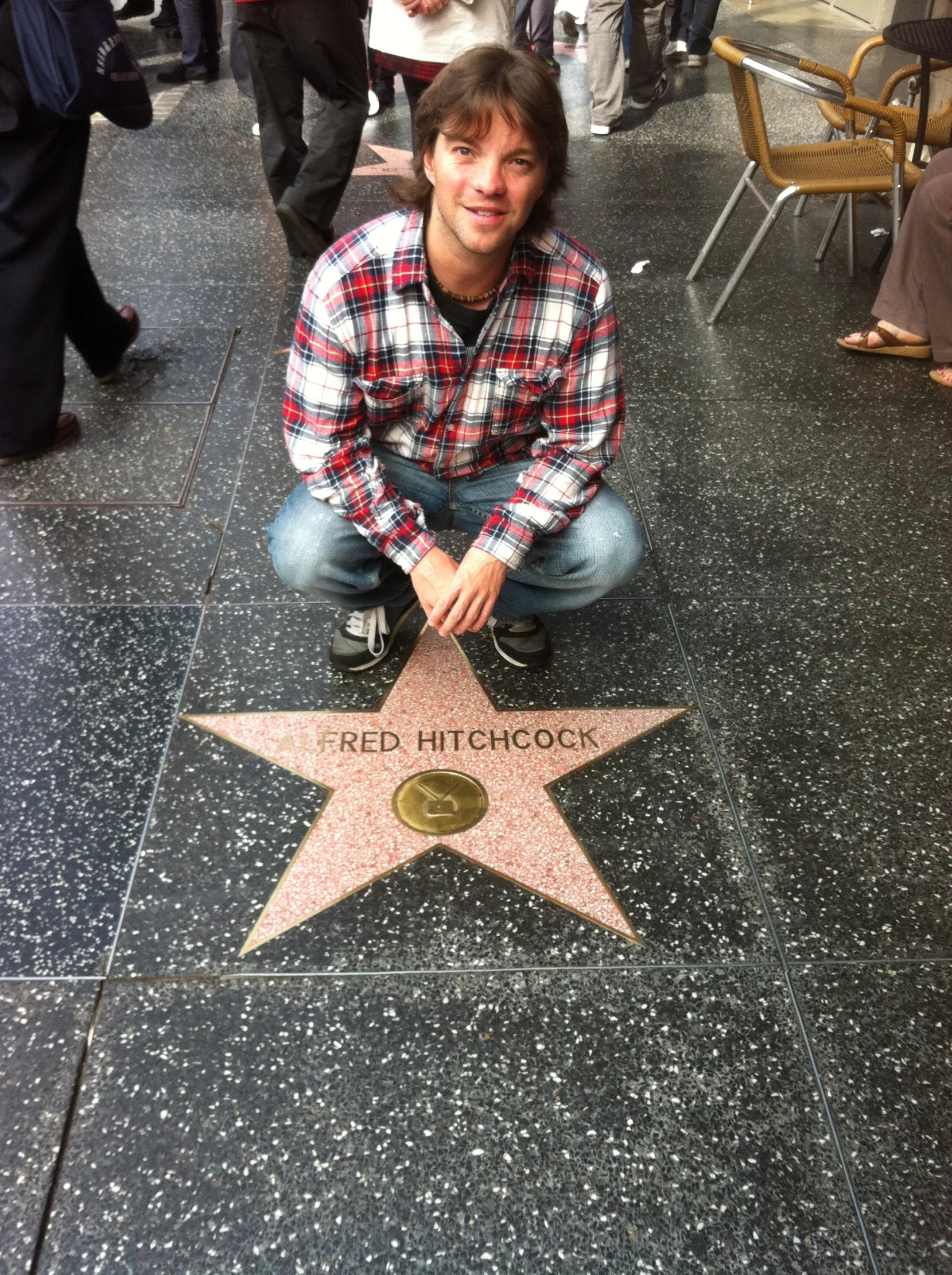 a young man sitting on a star that has his hands in his pockets