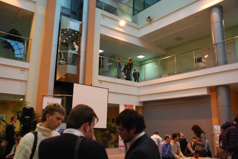 people crowd in an atrium near overhead balconies