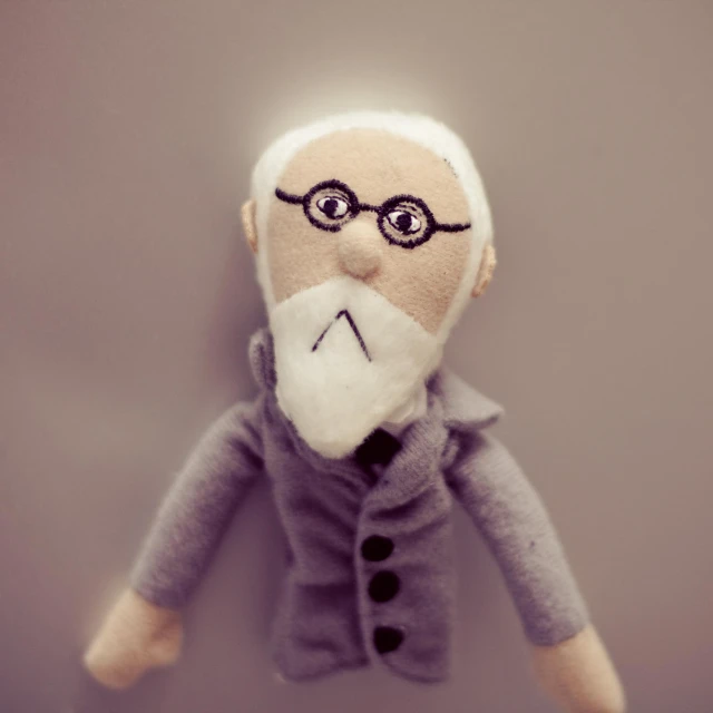 an old man plush toy with a mustache and grey jacket