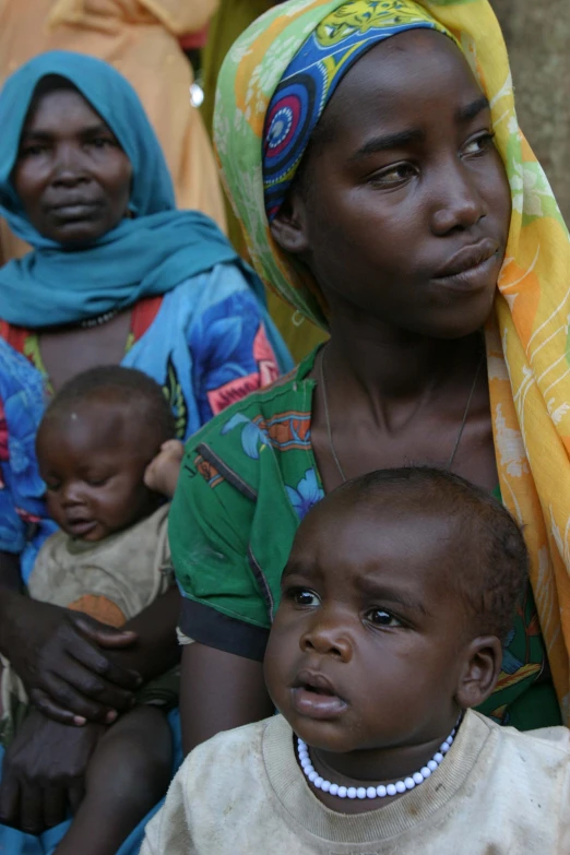 a woman wearing a head scarf and two children