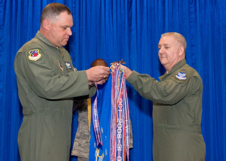 two army personnel prepare to display their ribbons