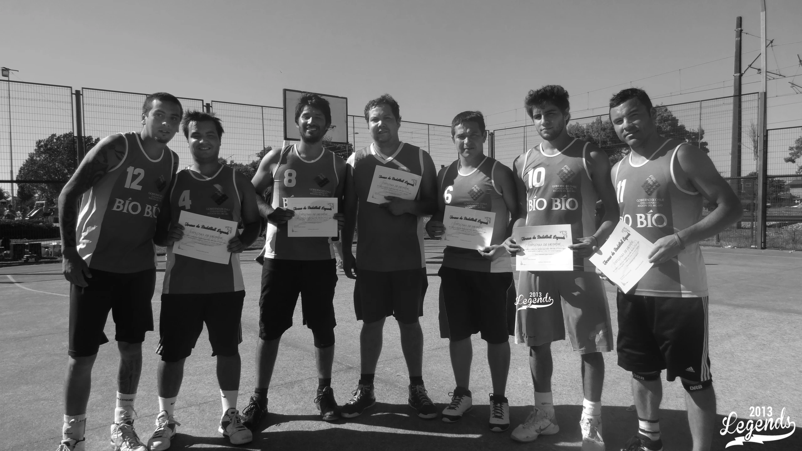 the men's basketball team poses with their scoreboards