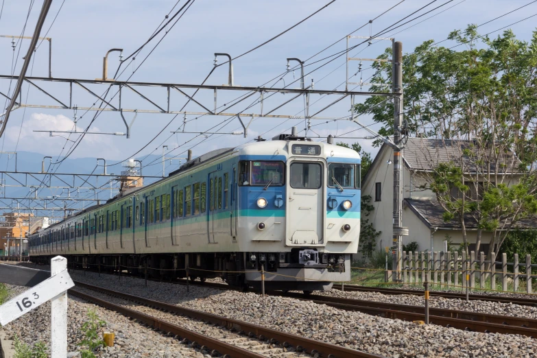 a train that is on some tracks next to the grass