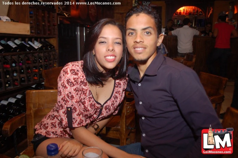 a couple posing for a picture while standing next to each other at a wine tasting