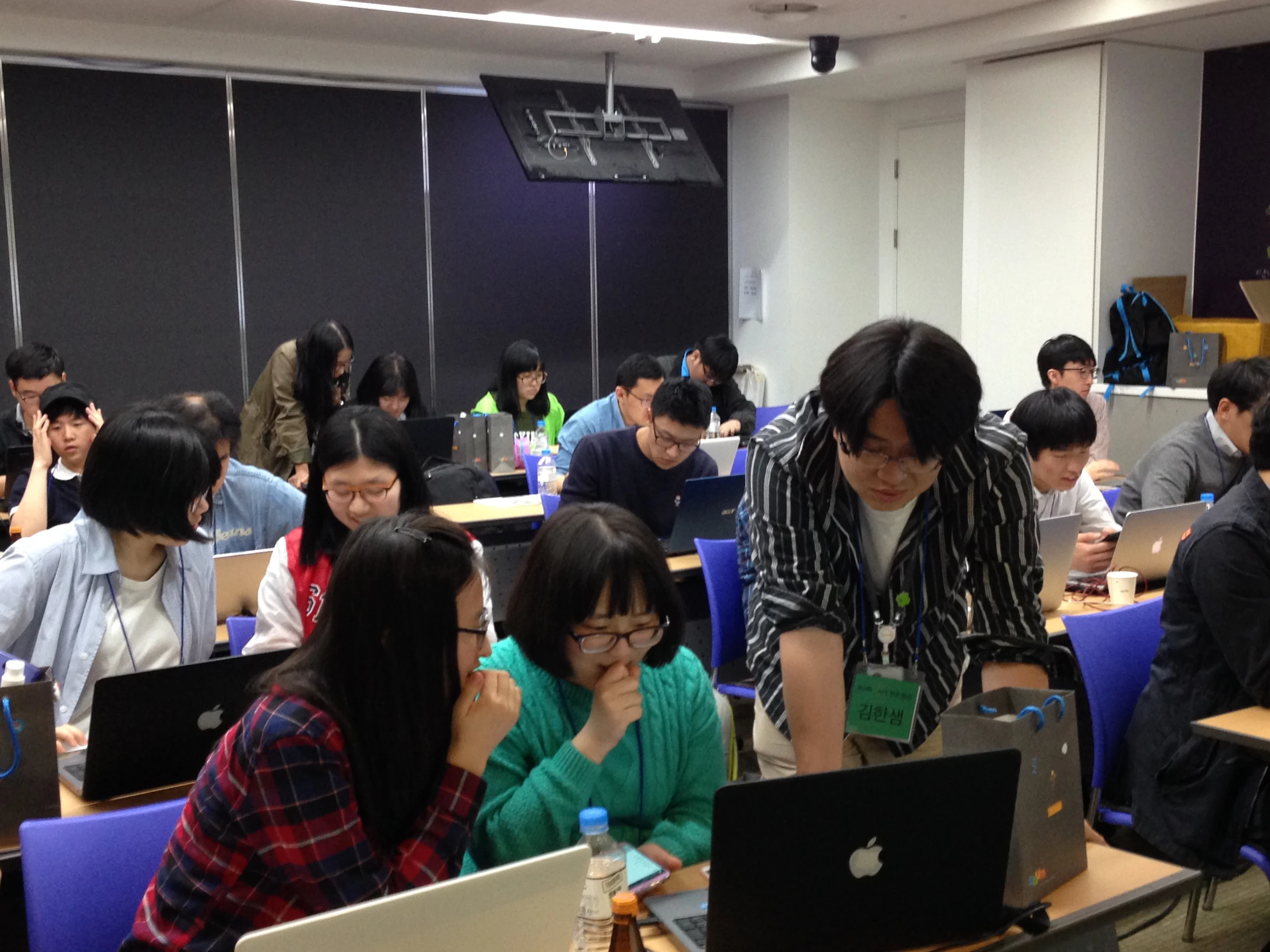 a group of people sitting in a classroom at computers