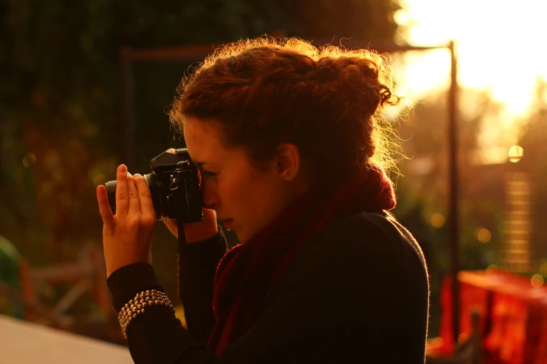 a woman taking pictures with her camera in the sunshine