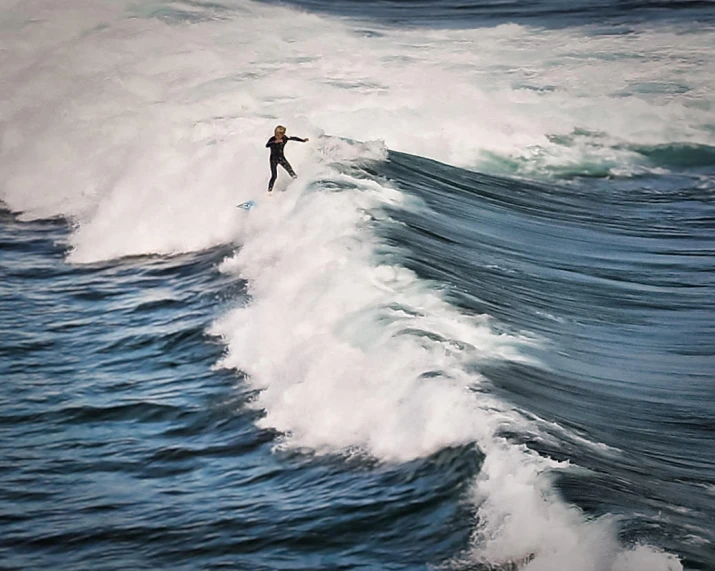 a person is surfing on the crest of the waves